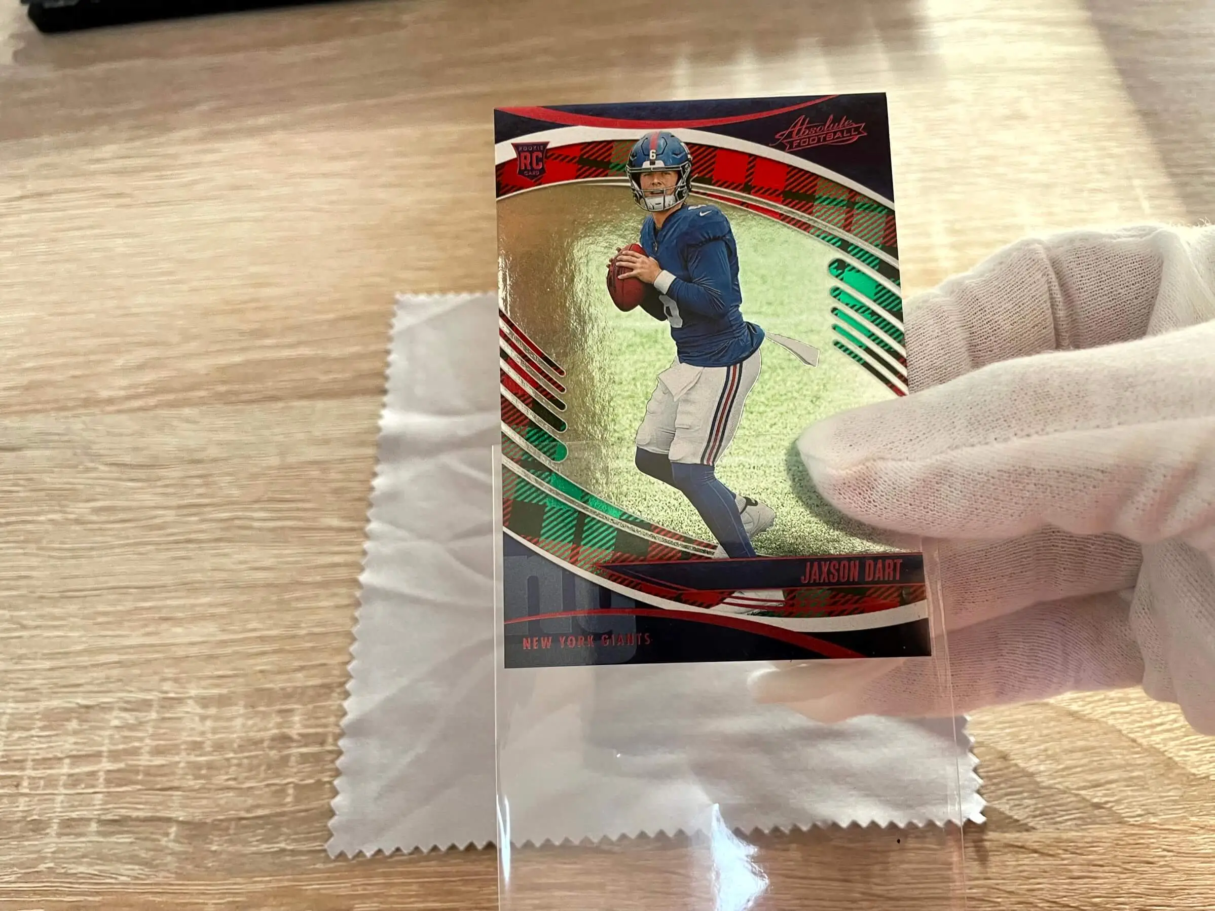 A card being gently inserted into a penny sleeve without touching the surface