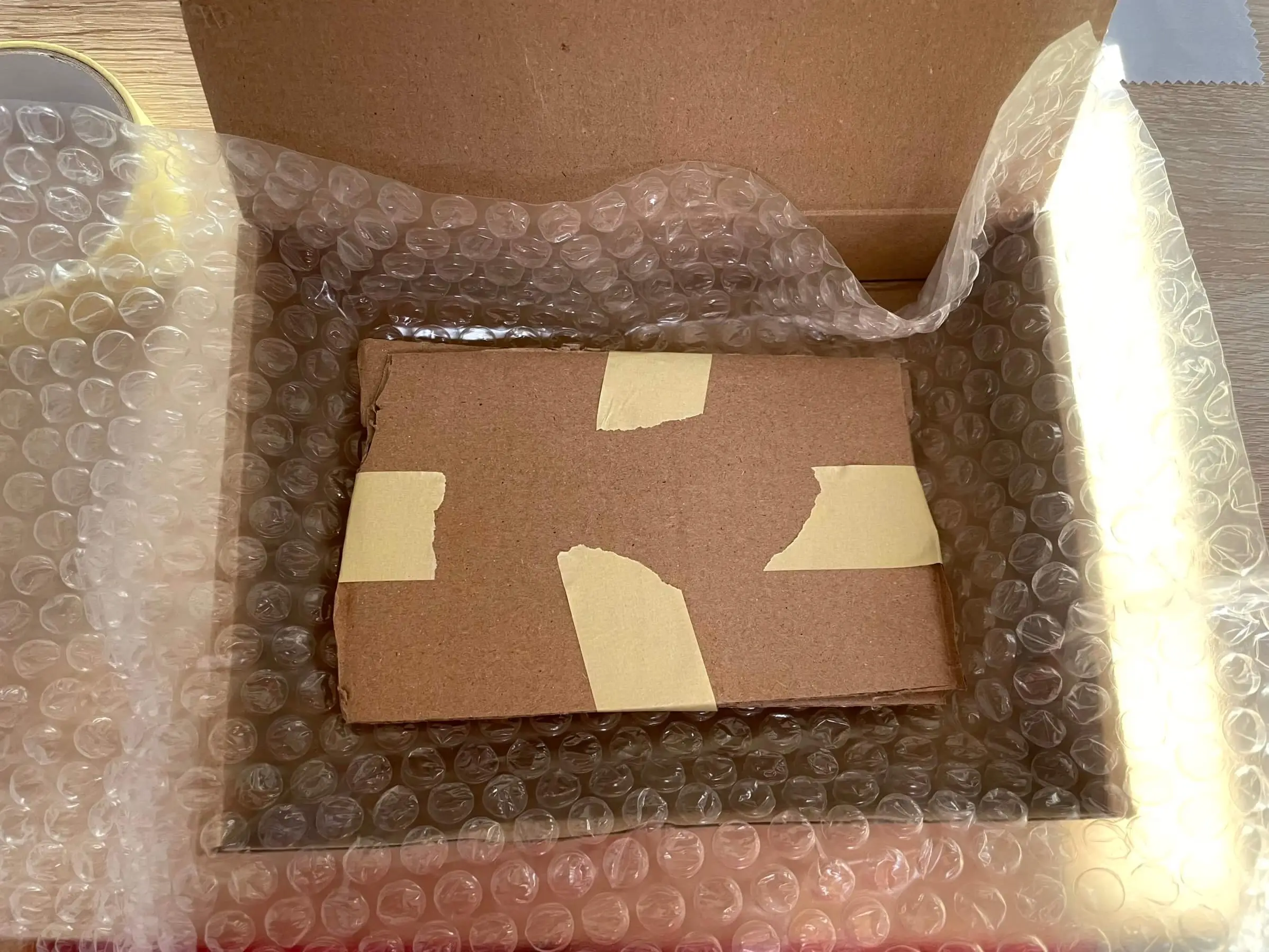 Cardboard sandwich bundle wrapped in bubble wrap for shipping protection