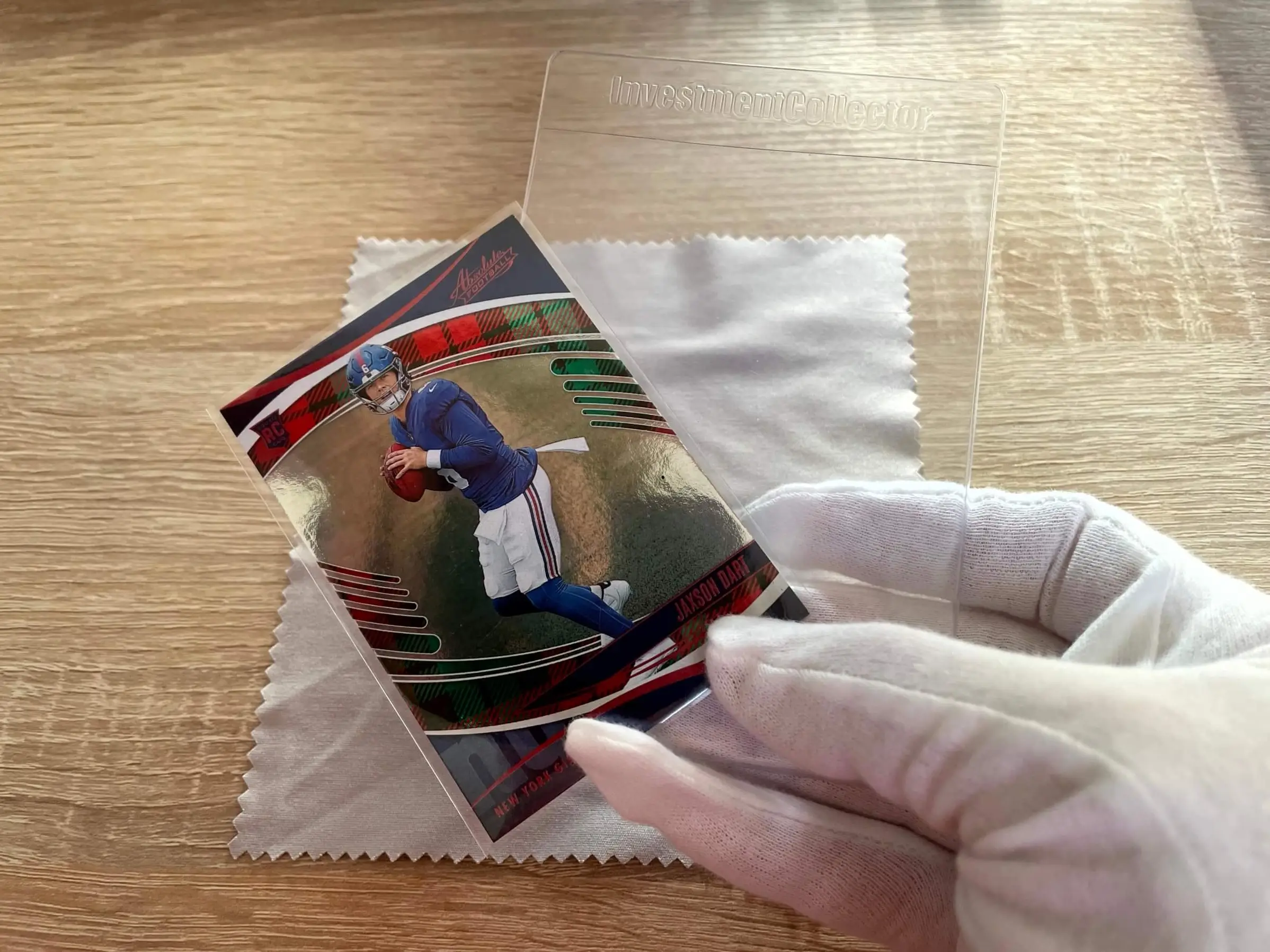 A sleeved card being inserted into a semi-rigid Card Saver style holder